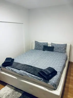 a bed with blue pillows on it in a room at Apartman 007 in Jajce