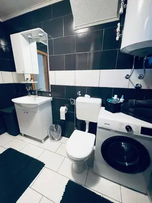 a bathroom with a toilet and a washing machine at Apartman 007 in Jajce