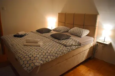 a large bed with pillows and two lamps on top at ViGoSt in Banja Luka