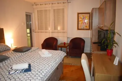 a bedroom with a bed and two chairs and a table at ViGoSt in Banja Luka