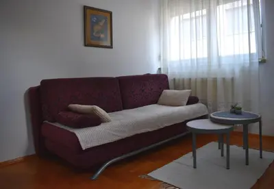 a living room with a purple couch and a table at ViGoSt in Banja Luka
