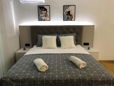 a bedroom with a large bed with two pillows at Apartman NINA in Doboj