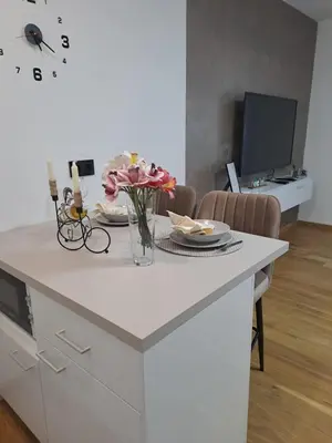 a kitchen counter with a vase of flowers on it at Apartman NINA in Doboj