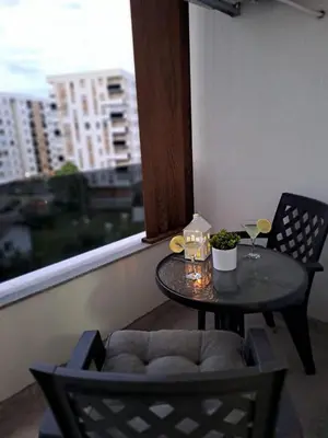 a small table and chairs on a balcony with a window at Apartman NINA in Doboj