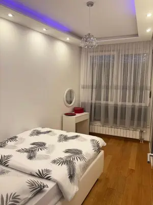 a bedroom with a bed and a chandelier at Apartman 888 in Banja Luka