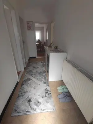 a room with two beds and a table and a rug at VERANIJE Apartman in Livno