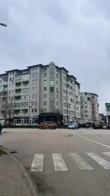 a large building with cars parked in front of it at Stan Centar in Sanski most
