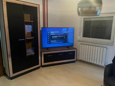 a flat screen tv sitting on a stand in a living room at Stan Centar in Sanski most
