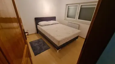 a small bedroom with a bed and a window at Stan Centar in Sanski most