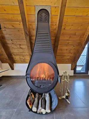 a fireplace in the middle of a room with logs at Luxury Villa Mašić in Čardaci