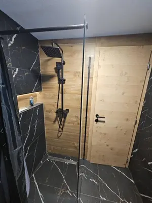 a shower in a bathroom with a wooden door at Luxury Villa Mašić in Čardaci