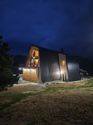 a large house with a metal facade at night at Luxury Villa Mašić in Čardaci