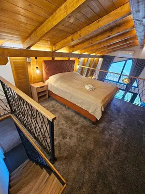 a large bedroom with a bed and a staircase at Luxury Villa Mašić in Čardaci