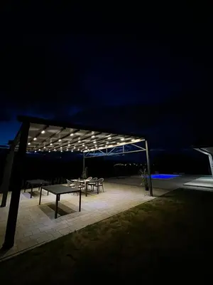 a group of picnic tables under a canopy at night at La Casa di Anna in Slatina Varoš