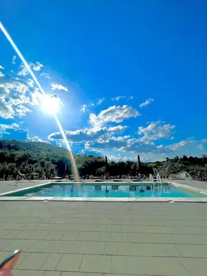 a large swimming pool with the sun in the sky at La Casa di Anna in Slatina Varoš