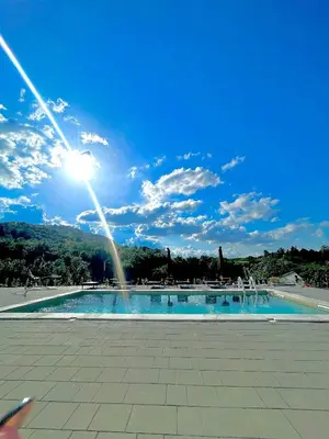 a large swimming pool with the sun in the sky at La Casa di Anna in Slatina Varoš