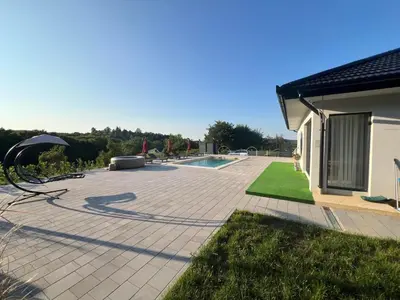 a patio with an umbrella and a swimming pool at La Casa di Anna in Slatina Varoš