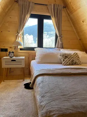 a bedroom with a large bed and a window at Vila Jezero-Jajce in Jezero