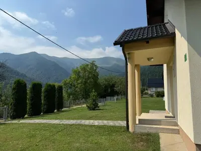 a building with an open door with mountains in the background at Kuća za odmor- Fojnica in Tješilo
