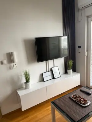 a living room with a tv on a white cabinet at Apartmani LUX Tamara in Banja Luka