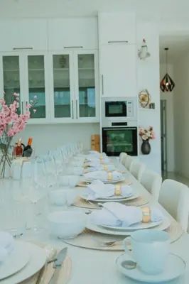 a long table with white plates and cups on it at Vila Salkic in Cazin