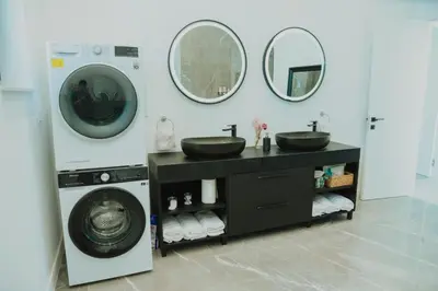 a bathroom with two sinks and a washing machine at Vila Salkic in Cazin