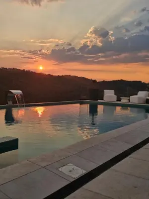 a swimming pool with a sunset in the background at Vila Salkic in Cazin