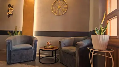 a room with two chairs and a clock on the wall at Wellness Spa Hotel Zeleni Raj in Banja Luka