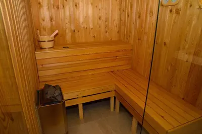 a wooden sauna with a bench and a trash can at Wellness Spa Hotel Zeleni Raj in Banja Luka