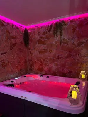 a bathroom with a red tub with pink lighting at Wellness Spa Hotel Zeleni Raj in Banja Luka