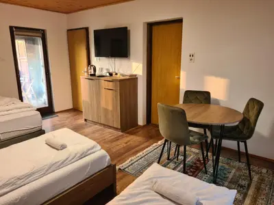 a hotel room with a bedroom with a table and a bed at Whispering Pines in Šišava