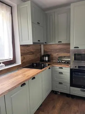a kitchen with white cabinets and a wooden counter top at Whispering Pines in Šišava
