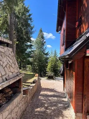 a stone walkway next to a building with trees at Whispering Pines in Šišava