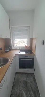 a small kitchen with a sink and a window at Apartman Katić in Odžak