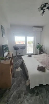 a bedroom with a bed and a desk and a window at Apartman Katić in Odžak