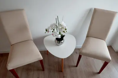 two white chairs and a table with a vase of flowers at Theatre View Banja Luka in Banja Luka