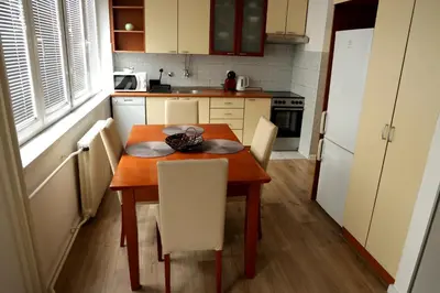 a small kitchen with a wooden table and chairs at Theatre View Banja Luka in Banja Luka