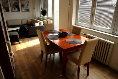 a dining room table and chairs in a living room at Theatre View Banja Luka in Banja Luka