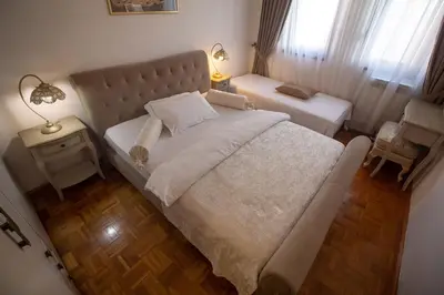a bedroom with a large bed and a table and a lamp at Apartment Barby - Aleja in Banja Luka