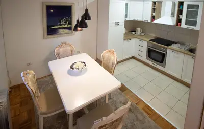 a small kitchen with a white table and chairs at Apartment Barby - Aleja in Banja Luka
