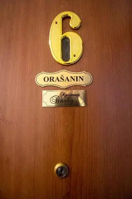 a sign on a wooden door with a sign on it at Apartment Barby - Aleja in Banja Luka