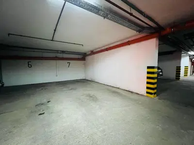 an empty parking garage with a large white wall at Apartman Tara 11 in Banja Luka