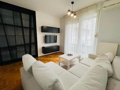 a living room with a white couch and a table at Apartman Tara 11 in Banja Luka