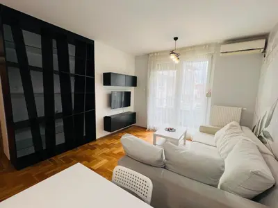 a living room with a white couch and a window at Apartman Tara 11 in Banja Luka