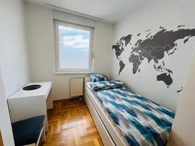a bedroom with a map of the world on the wall at Apartman Tara 11 in Banja Luka
