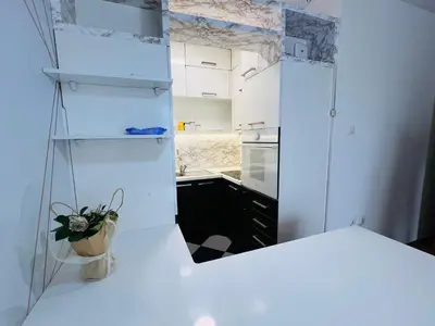 a white kitchen with a mirror on the wall at Apartman Tara 11 in Banja Luka