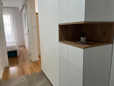 a kitchen with white cabinets and a wooden counter top at Apartman Delta in Banja Luka