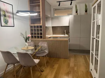 a kitchen and dining room with a glass table and chairs at Apartman Delta in Banja Luka
