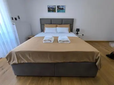 a bedroom with a large bed with two towels on it at Apartman Vanja in Doboj
