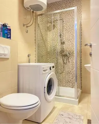 a bathroom with a washing machine and a shower at Stan na dan Banja luka Mejdan in Hiseti